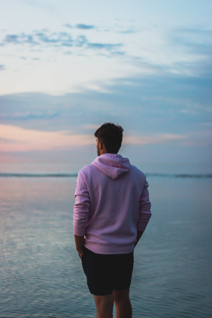 Anonymous man admiring seascape at sunset